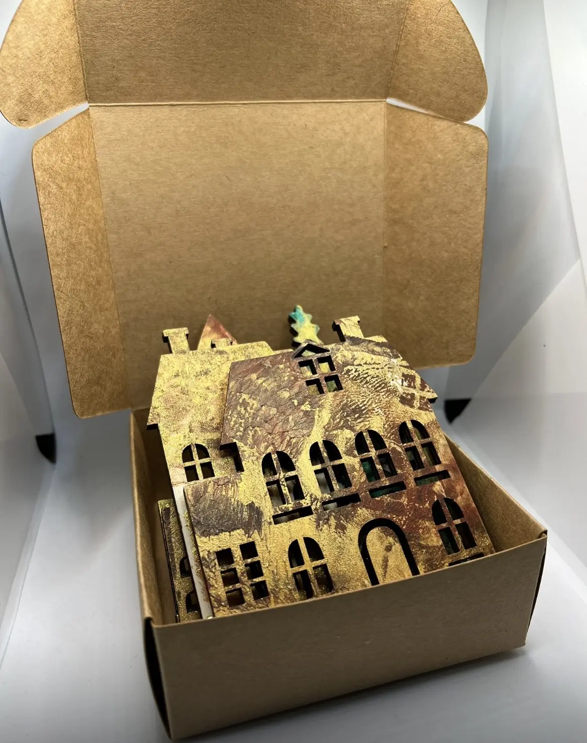 Gift box containing golden house decorations.